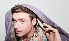 Headshot of actor Richard Madden with jacket draped over the back of his head
