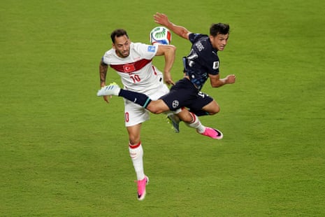 Hakan Calhanoglu (10) of Turkey competes for the ball against Andres Cubas (14) of Paraguay.