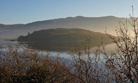 Ynys Gitan in the mist with reflection of island and clear blue sky at dawn