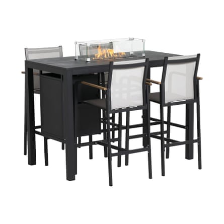 A tall black rectagular table. There are 2 black and white stools with arms and backs on either side. In the centre of the table is a transparent box with a flame, which is an in-built fire pit.