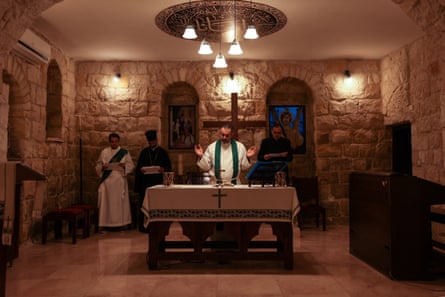 Fadi Diab in ecclesiastical robes leads a Christian service in a small stone church