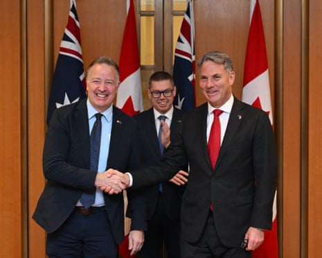 Richard Marles and Stephen Fuhr shake hands after signing the defence export deal.