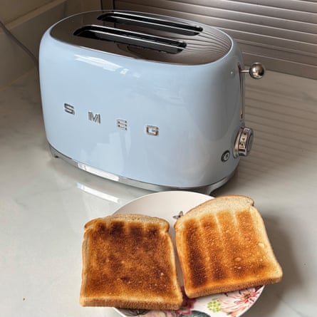 A blue Smeg Two Slice Toaster with two slices of toast on a plate on worktop