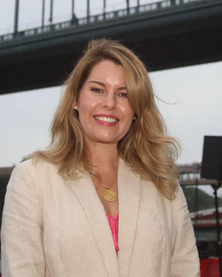 Smiling woman with long blond hair and beige blazer.