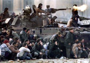 Bucharest’s residents protect themselves from the crossfire between an army tank and pro-Ceausescu troops during clashes in the Republican square in Bucharest 23 December, 1989. “I shot the fighting with a long lens as if I was covering a soccer game,” said Platiau, who had started out as a sports photographer. There was no time to take any more pictures and only just enough time to process and send a single colour print to meet Sunday newspaper deadlines.