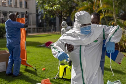 People in full PPE in a garden.