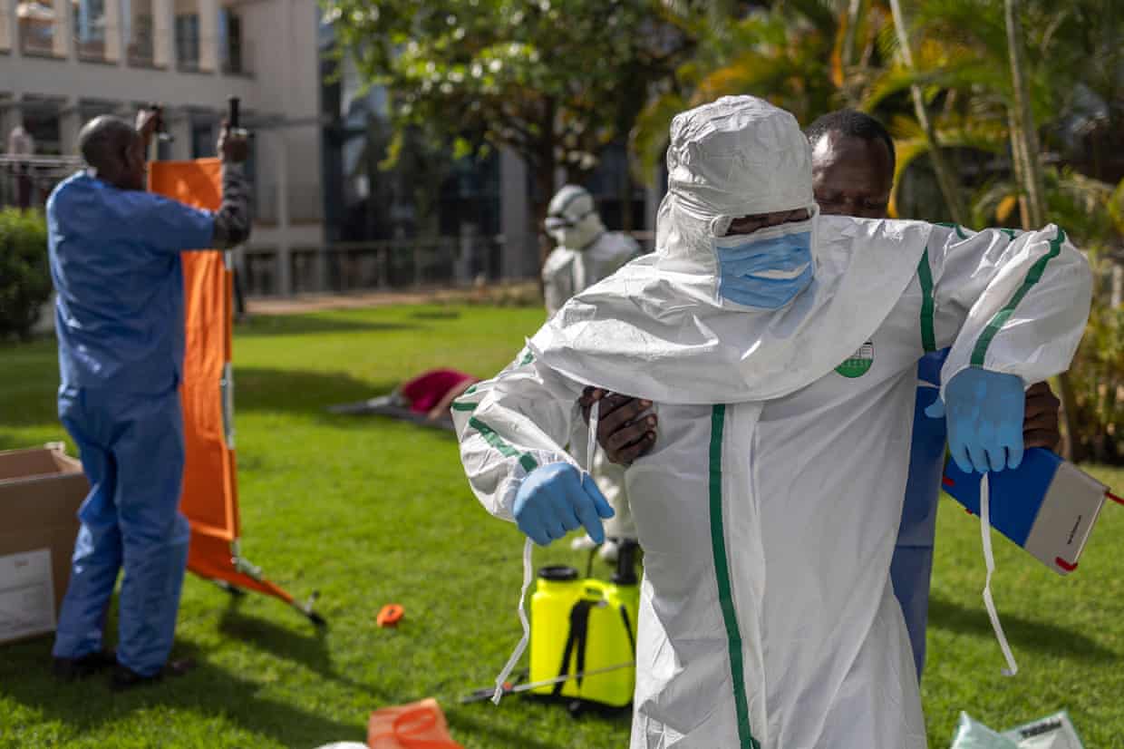 People in full PPE in a garden.