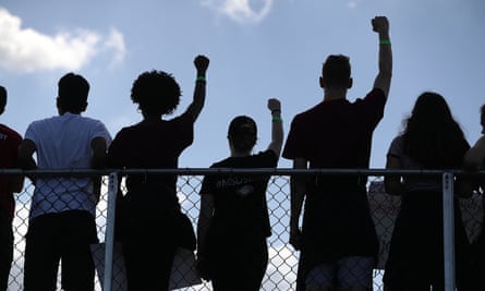 Marjory Stoneman Douglas high school students hold their fists up in the air as they participate in the March For Our Lives.