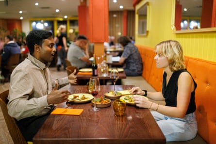 Eshwar and Georgia chatting across a restaurant table