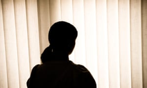 Silhouette of a woman against blinds