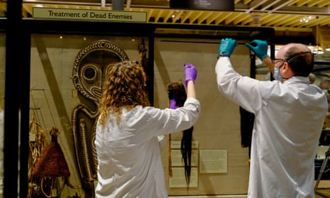 Staff remove the shrunken heads, or tsantsas, from Peru and Ecuador, from the ‘Treatment of Dead Enemies’ cabinet.