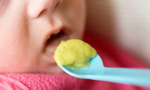 A baby is fed puréed food