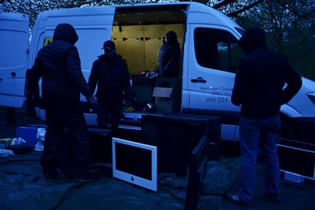 People loading appliances into a van