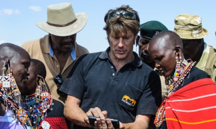 Frank Pope of Save The Elephants explains to Maasai women how a mobile phone is used to see the location of an elephant fitted with a tracking collar, in Amboseli National Park, Kenya, 10 September 2016.