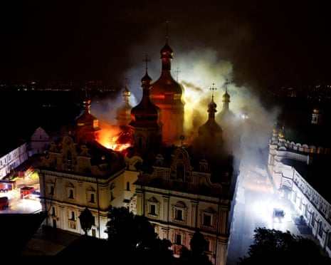 The Kyiv Pechersk Lavra cathedral burns at night, with flames and smoke rising between the towers
