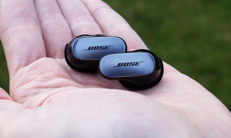 Bose QC Ultra earbuds review sitting in the palm of a hand.