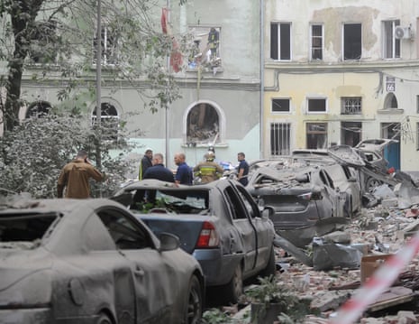 Cars were damaged as rubble and debris littered the street.
