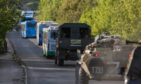 Russian military vehicles escort buses carrying Ukrainian servicemen from the besieged Azovstal steel plant.