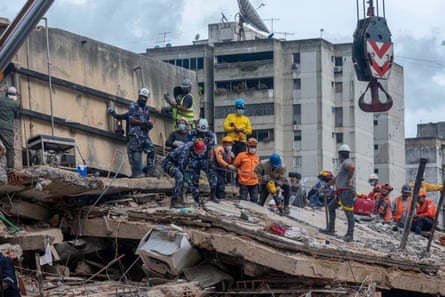 A crane is used to move sections of collapsed buildings