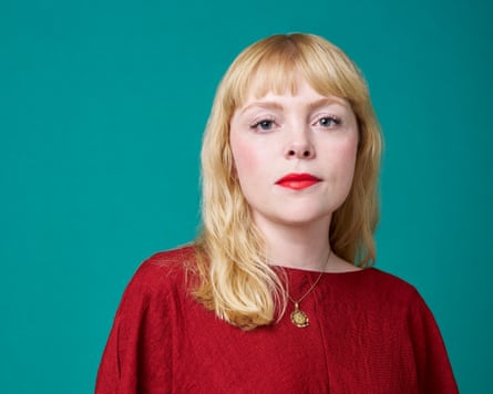 Megan Nolan wearing a red dress against a turquoise background