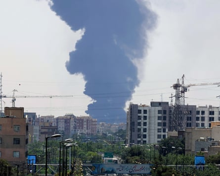 Smoke from an oil refinery rises over residential buildings in southern Tehran after Israeli airstrikes.
