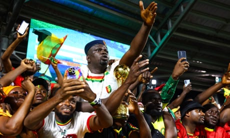 Guinea supporters inside the stadium celebrate the win over the Gambia in safety.