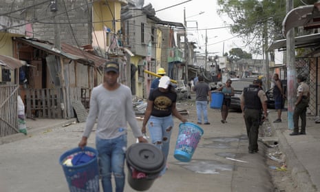 Residents carry out their belongings after an explosion left people injured or dead and destroyed several houses and vehicles in Guayaquil, Ecuador on Sunday.