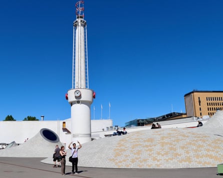 A tower and curved brick structures against bright blue sky