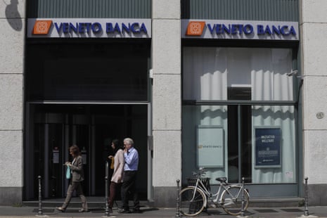 People walk past by a Veneto Banca branch in Milan, Italy, Monday, June 26, 2017