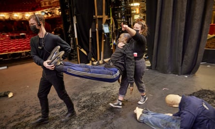 The props team arrange dummy corpses, 10 in all, on stage. Each position has been carefully planned out in advance by the Set Designer