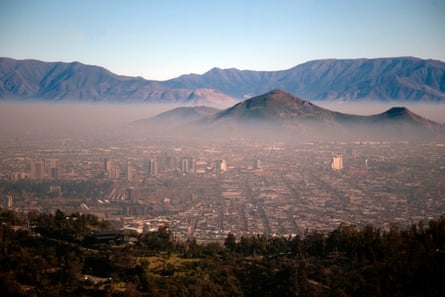 View of smog hanging over the city, as mountains surround it, towering above the smog