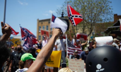Anti-racist protesters raise fists towards supporters of the Confederacy at the Alamance county courthouse at at a rally in Graham, North Carolina, on 11 July.