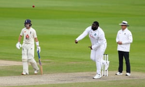 West Indies’ Rakheem Cornwall bowls as England’s Ollie Pope looks on.