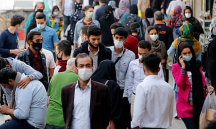 Iranians wearing face masks walk in at the Tajrish bazaar in Tehran, Iran