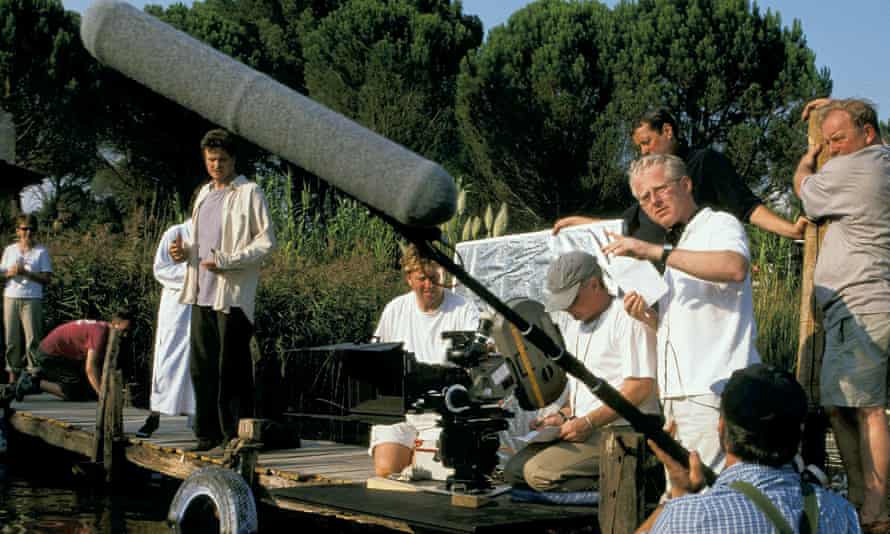 Richard Curtis gestures on the set of Love Actually as the actor Colin Firth (fourth from left) prepares for a scene.