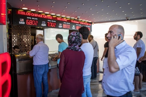 People line up to exchange money at a currency exchange office in Istanbul, Turkey