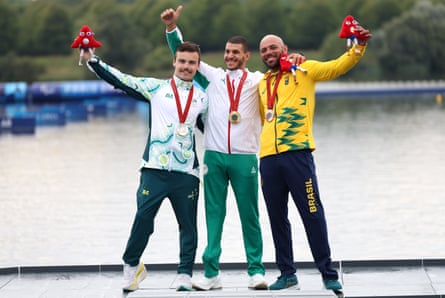 Brahim Guendouz celebrates on the podium with silver medallist Dylan Littlehales and bronze medallist Miquéias Elias Rodrigues