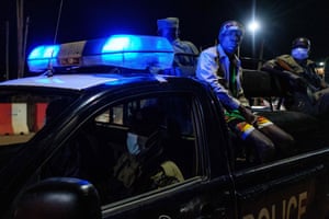 Police officers take a man into custody as they patrol on a streel during the curfew after 7pm in Kamapala, Uganda, on 29 April 2020