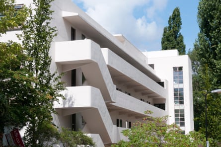 A white building with long outdoor access decks that jut out, making it look a bit like a modern cruise ship