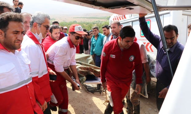 Rescue workers carrying the body of a victim after flooding in Estahban county, Fars province, southern Iran.