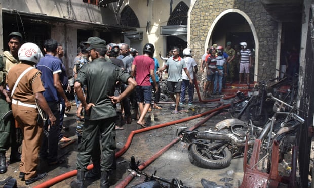 Locals and police gather at a church in Colombo after an explosion
