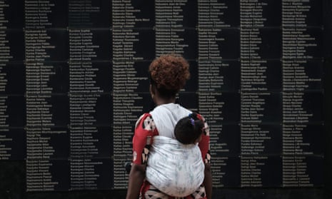 A woman carrying her child looks at the wall of victims' names at the Kigali Genocide Memorial in Rwanda.