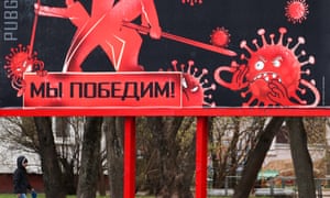 A young man walks a dog by a billboard reading “We will win” in Minsk, Belarus.