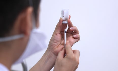 A doctor draws AstraZeneca vaccine from a vial.