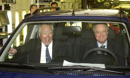 Osamu Suzuki in the passenger seat of the first Suzuki Ignis made in Hungary with the Hungarian prime minister Péter Medgyessy at the wheel, on the production line in Esztergom near Budapest, 2003.