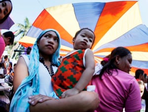 Manila, Philippines A Filipino mother with her child march during a parade to mark International Women’s Day