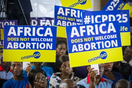 A group of people hold yellow and blue placards that read ‘Africa does not welcome abortion’.