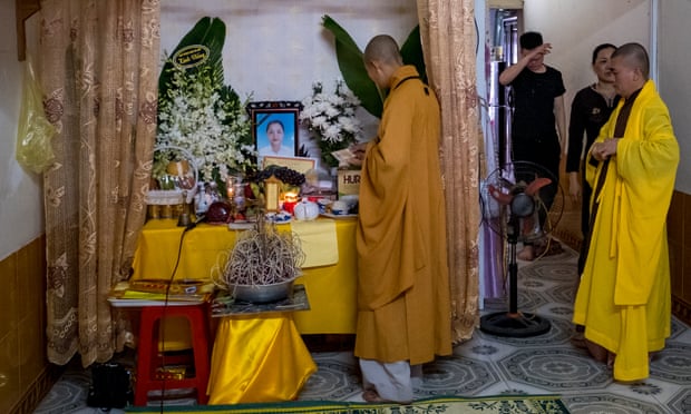 Family members and neighbours of Pham Thi Tra My attend a praying ceremony with Buddhist monks in front of a makeshift shrine.