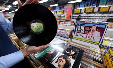 A shop manager shows off a period Japanese pressing of the Beatles’ final studio album, Let It Be, at the RECOfan music shop in Tokyo’s Shibuya district.