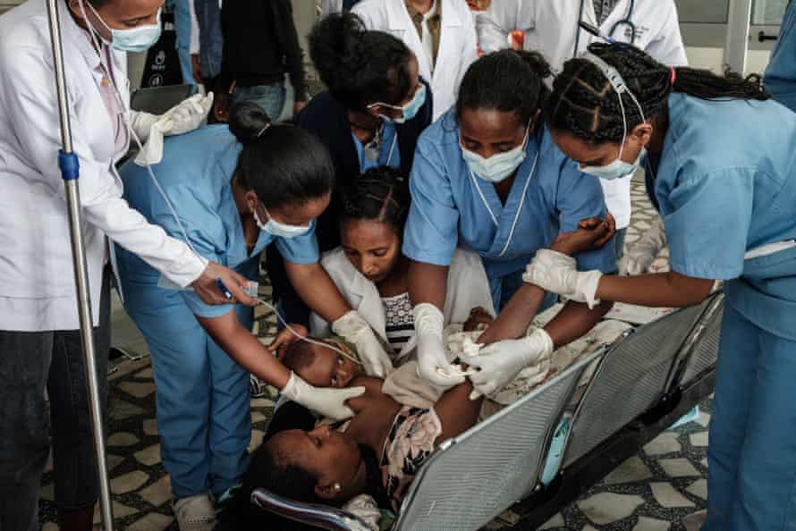 Lem Lem Hailemariam, 40, who had her knee fractured in her town Togoga in a deadly airstrike on a market, breast feeds her 3-month-old child as she receives medical treatments at the entrance hall of the Ayder referral hospital in Mekele, on June 24, two days after a deadly airstrike on a market